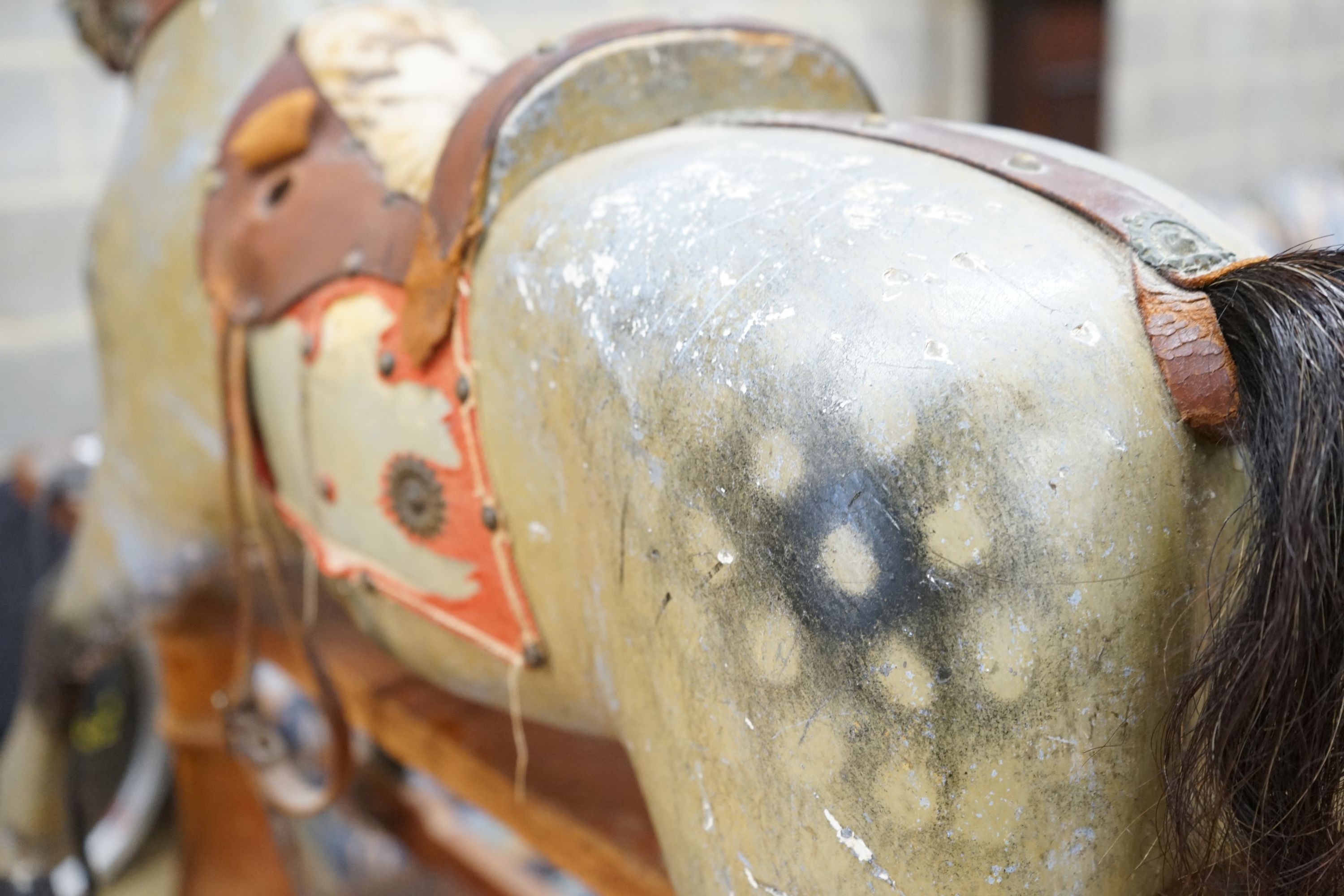 An Edwardian carved wood and dapple painted rocking horse, raised in a trestle frame, length 127cm, height 95cm